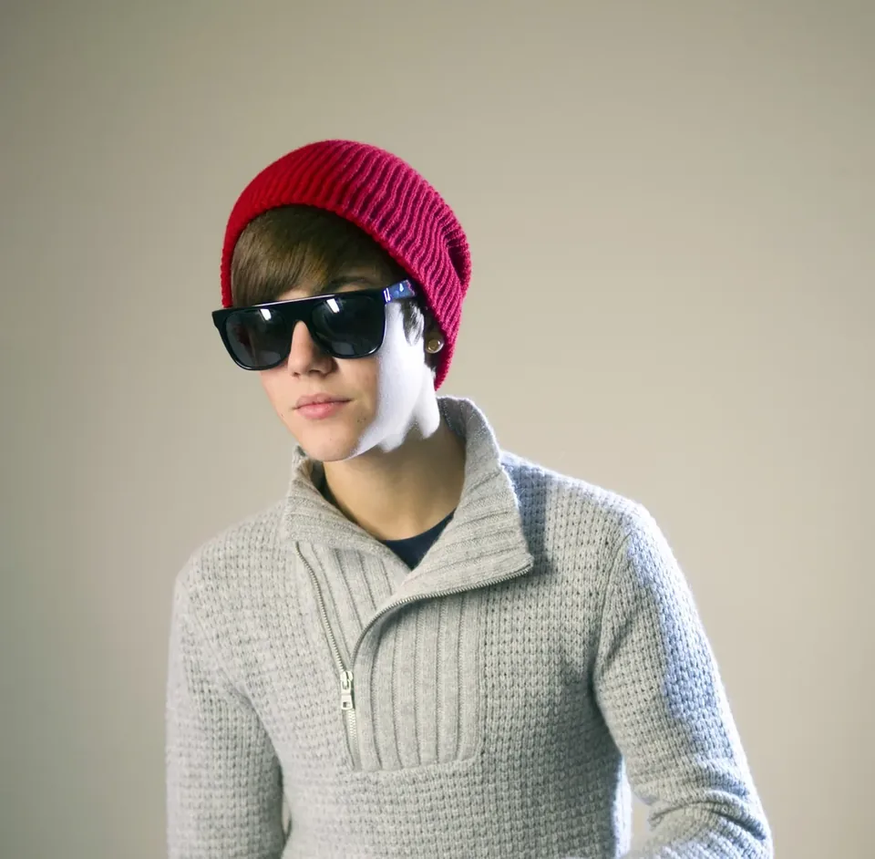 Studio portrait of a musician wearing sunglasses and a red beanie